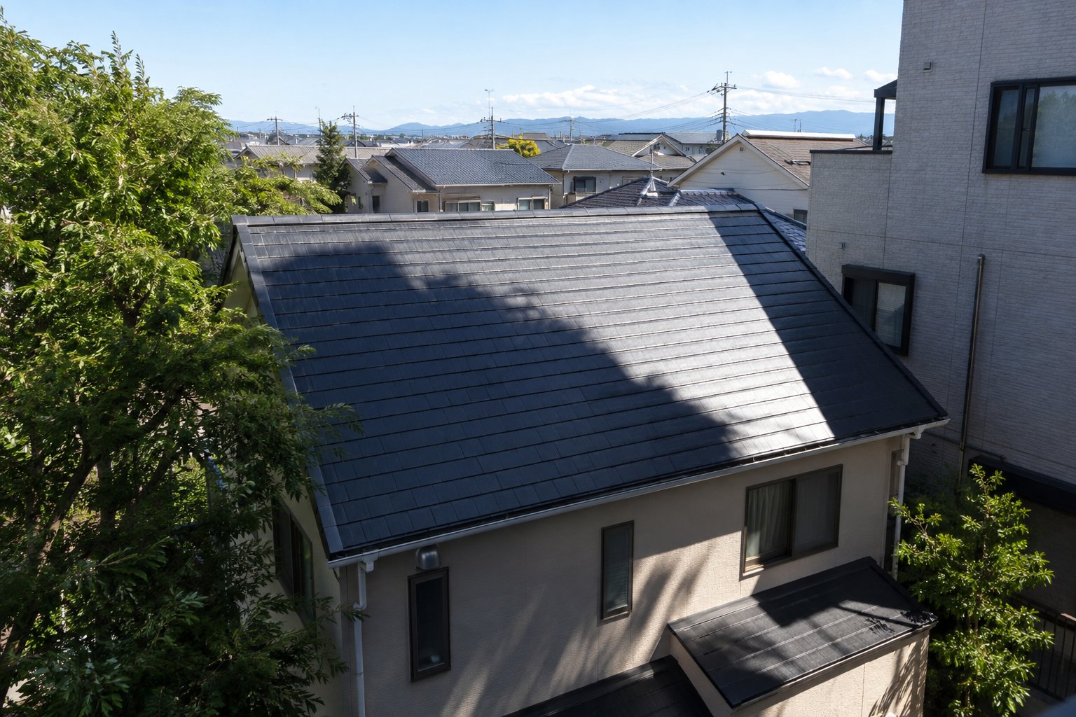 隣の建物の影がかかる住宅の屋根